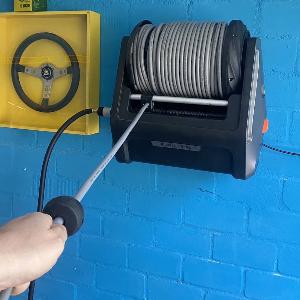 Just gently pull the hose of the Wall-Mounted Giraffe Tools Pressure Washer with Retractable Hose Just gently pull the hose of the Wall-Mounted Giraffe Tools Pressure Washer with Retractable Hose